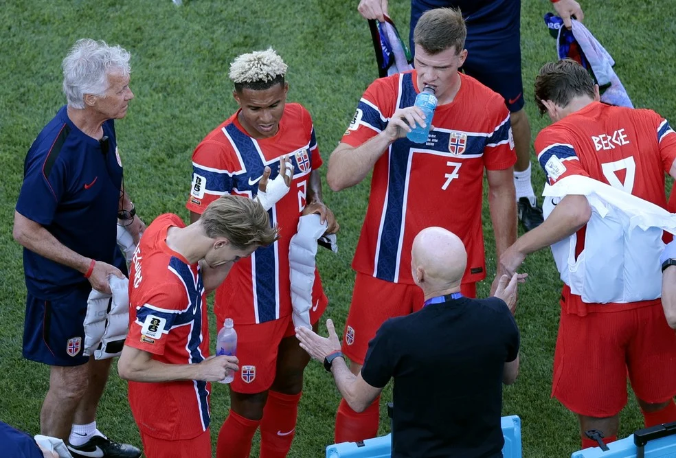 Jogadores da Noruega com coletes de resfriamento durante a pausa de hidratação