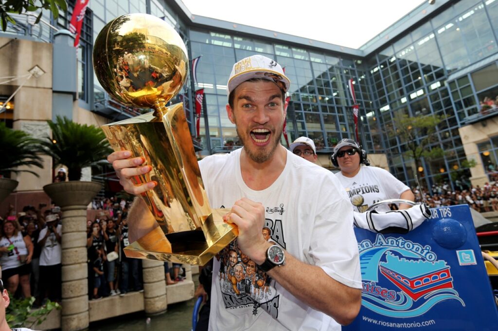 Tiago Splitter em destaque vestindo camisa de jogador do San Antonio Spurs