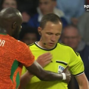 Árbitro Sebastian Gishamer recebendo atendimento médico durante jogo França x Costa do Marfim