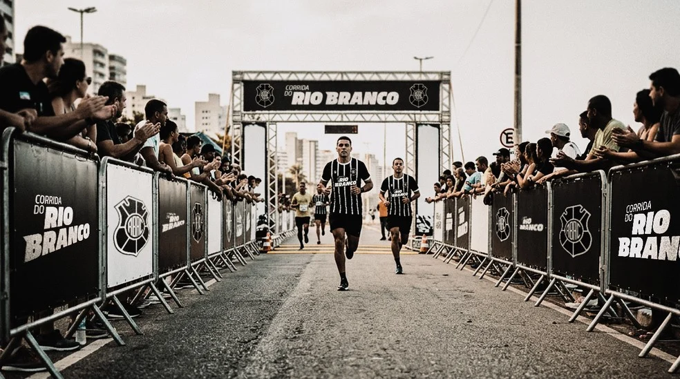 Atletas na Corrida do Rio Branco na orla de Camburi