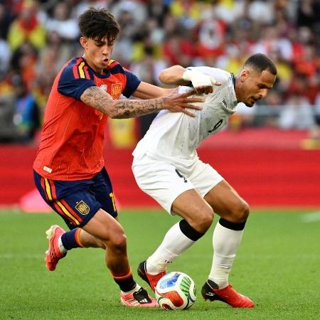 Jogadores disputando bola entre Espanha e Iraque no amistoso pré-Copa do Mundo