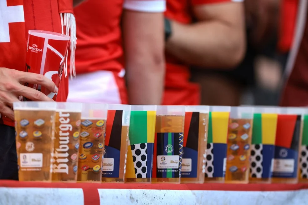 Torcedores com copos de cerveja no estádio — Preço da cerveja em destaque
