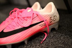 Detalhe das chuteiras de Mbappé com as inscrições KEWJF e a coroa