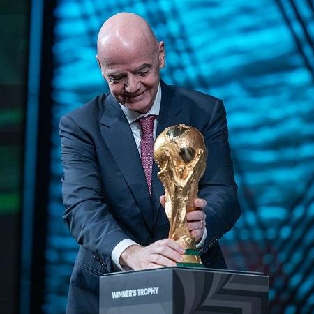 Gianni Infantino segurando a taça da Copa do Mundo