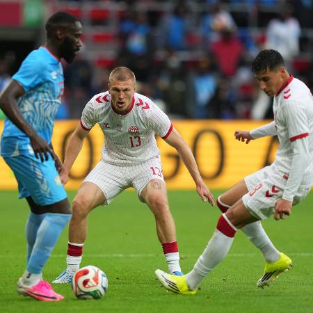 Jogadores de Dinamarca e República Democrática do Congo disputando bola em amistoso em Liege, Bélgica