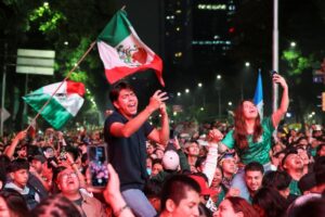 Torcida mexicana no Estádio Azteca com bandeiras tricolores