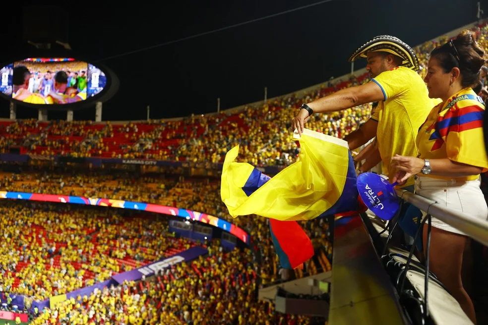Estádio amarelo com torcida colombiana