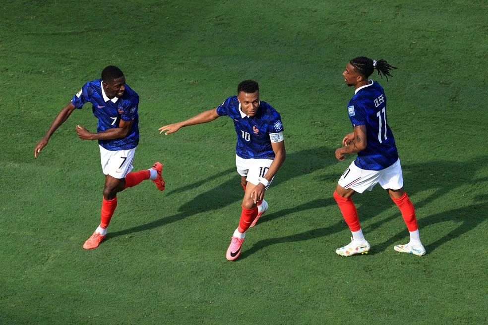 Trio da França comemorando gol - Mbappé, Dembélé e Olise