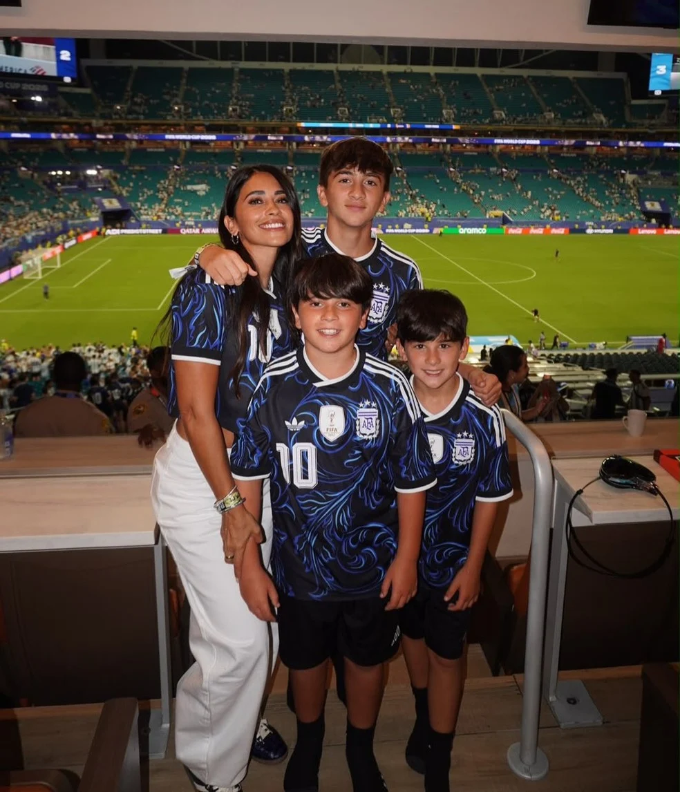 Antonella Roccuzzo com os três filhos no estádio após vitória da Argentina